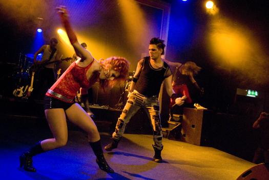 Skoglund Entertainment – Riggos Rullande Show - Numera väletablerade Skoglunds Entertainment eller som dom tidigare hette – Riggos Rullande – ger en show som vi brukar beskriva som folklig, festlig och fartfylld. En kväll med dessa artister är som en härlig musikalisk resa mellan kabaré, svensktopp, rock’n roll, schlagers och musikaler. På senare år har dom även gjort många uppskattade gala-middagar där fokus har legat på lite lyxigare och elegantare framtoning. Detta är en showgrupp som kompas av ett band och dom kan även åta sig uppdrag som konferencier. Gruppens konstellation är till stor del skalbar, så det finns nästan alltid ett koncept och en prisnivå som passar för eventet – oavsett plånbokens storlek.Skoglund Entertainment bjuder på massor med sång, musik och dans. Dom passar lika utmärkt i teater-salongen som till en middagsshow för personal eller kunder. Räkna med många kostymbyten och en hög musikalisk kvalitet. Repertoaren passar bra för både gammal och ung. Skoglund Entertainment är en av våra mest bokade shower och dom blir bara bättre från år till år. DSC9006 - Numera väletablerade Skoglunds Entertainment eller som dom tidigare hette – Riggos Rullande – ger en show som vi brukar beskriva som folklig, festlig och fartfylld. En kväll med dessa artister är som en härlig musikalisk resa mellan kabaré, svensktopp, rock’n roll, schlagers och musikaler. På senare år har dom även gjort många uppskattade gala-middagar där fokus har legat på lite lyxigare och elegantare framtoning. Detta är en showgrupp som kompas av ett band och dom kan även åta sig uppdrag som konferencier. Gruppens konstellation är till stor del skalbar, så det finns nästan alltid ett koncept och en prisnivå som passar för eventet – oavsett plånbokens storlek.Skoglund Entertainment bjuder på massor med sång, musik och dans. Dom passar lika utmärkt i teater-salongen som till en middagsshow för personal eller kunder. Räkna med många kostymbyten och en hög musikalisk kvalitet. Repertoaren passar bra för både gammal och ung. Skoglund Entertainment är en av våra mest bokade shower och dom blir bara bättre från år till år.