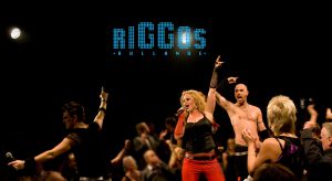 Riggos1 - Numera väletablerade Skoglunds Entertainment eller som dom tidigare hette – Riggos Rullande – ger en show som vi brukar beskriva som folklig, festlig och fartfylld. En kväll med dessa artister är som en härlig musikalisk resa mellan kabaré, svensktopp, rock’n roll, schlagers och musikaler. På senare år har dom även gjort många uppskattade gala-middagar där fokus har legat på lite lyxigare och elegantare framtoning. Detta är en showgrupp som kompas av ett band och dom kan även åta sig uppdrag som konferencier. Gruppens konstellation är till stor del skalbar, så det finns nästan alltid ett koncept och en prisnivå som passar för eventet – oavsett plånbokens storlek.Skoglund Entertainment bjuder på massor med sång, musik och dans. Dom passar lika utmärkt i teater-salongen som till en middagsshow för personal eller kunder. Räkna med många kostymbyten och en hög musikalisk kvalitet. Repertoaren passar bra för både gammal och ung. Skoglund Entertainment är en av våra mest bokade shower och dom blir bara bättre från år till år. 