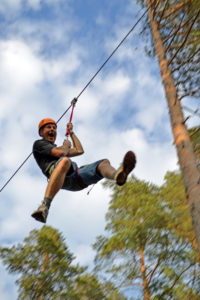 DSC 085 korrad - Höghöjdsbana och zipline i natursköna Julared, ca. 30 min från Jönköping. En zipline består av en lång uppspänd vajer. Med hjälp av en trissa, fastspänd i en kroppssele, glider åkaren nerför vajern i full fart. Hastigheten kan komma upp i nästan 40 km/h beroende på åkarens vikt, vajerns lutning och vindmotståndet från kroppen. En av vajrarna är uppspänd över en gammal kvarndamm, de andra är uppspända i skogen. Höghöjdsbanan består av nio plattformar och nio hinder som är byggda cirka åtta meter ovanför marken. Med i gruppen finns alltid minst en guide som ansvarar för säkerheten under besöket. Detta är ett adrenalinfyllt äventyr med inslag av höga höjder och hastigheter i vacker skogsmiljö.