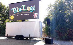 Bio Logi Utomhusbio 1 e1562071152488 - Vår lösning för utomhusbio bygger på en högupplöst LED-skärm som levereras i form av en trailervagn med tillhörande ljudsystem i mycket hög kvalitet. Detta är ett snabbt och smidigt sätt att få ut en storbildsskärm till en liten eller stor publik. Vi har allt ni behöver för att genomföra detta. Film kan visas från dator, DVD, Blueray eller liknande. Det finns också möjlighet att projicera på en befintlig vit vägg med kraftfull projektor.